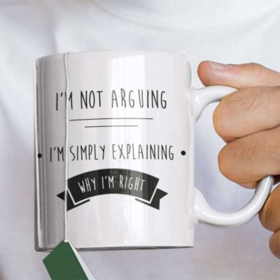 A Closeup Photograph of a mug with I'm Not Arguing I'm Explaining Why I'm Right printed on the front