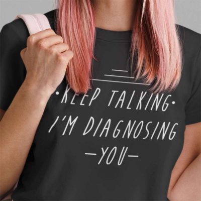 A Close up Photo of a Black t shirt with the words Keep Talking I'm Diagnosing You printed on the front