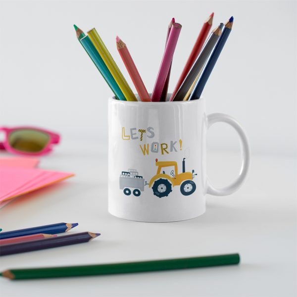 A photo mug with the colourful words Lets Work Printed on it alsong with a yellow hand drawn tractor and trailer