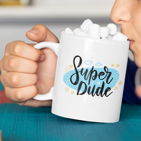A Close up of a Mug with super dude blue with clouds and stars printed