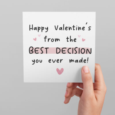 A hand holding a square white card with the words happy valentine's from the best decision you ever made!